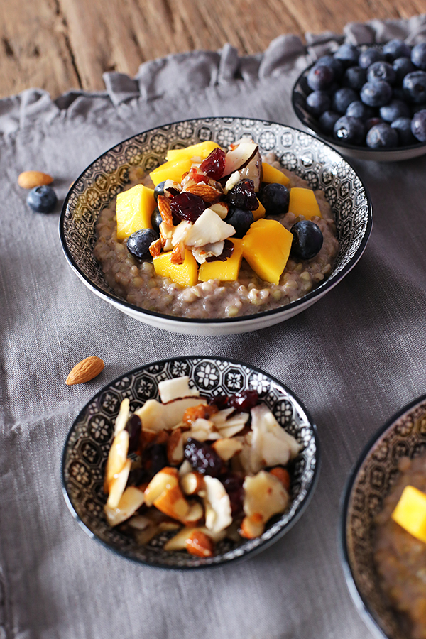 Rezept Frühstück Buchweizen-Porridge mit Mango und Blaubeeren und karamellisierten Mandeln,  Cranberries und Kokoschips